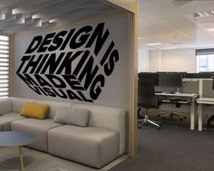 a couch sitting in front of a wall with the words design is thinking and visual on it