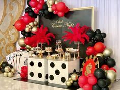 a casino themed birthday party with black, gold and red balloons in the shape of palm trees