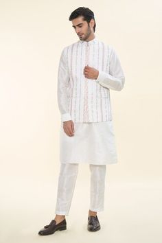 Off white solid kurta. Paired with a Nehru Jacket with thread embroidery and a matching plain mexican pant. - Aza Fashions White Traditional Bandhgala For Spring, White Nehru Jacket With Stand Collar For Festive Occasions, Festive White Outerwear With Chikankari Embroidery, White Festive Nehru Jacket With Stand Collar, Festive White Nehru Jacket With Stand Collar, White Stand Collar Kurta For Eid, White Fitted Kurta With Stand Collar, White Chikankari Embroidery Outerwear For Eid, White Bandhgala With Chikankari Embroidery For Spring