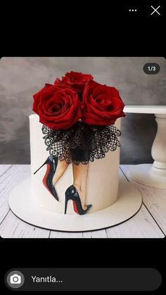 a white cake decorated with red roses and high heels