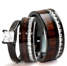 two wooden rings with white diamonds on each one and an engagement ring in the middle