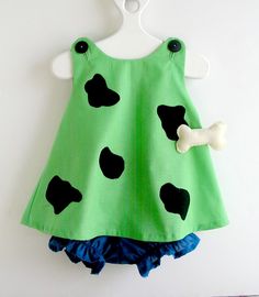 a green dress with black spots and a bone on it