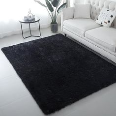 a white couch sitting next to a black rug