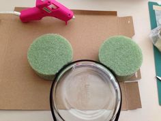 cupcakes with green frosting and ears are on a table next to a pair of scissors