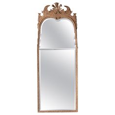 an ornate wooden mirror hanging on the wall