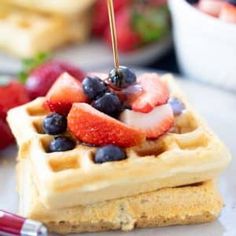 a waffle topped with strawberries and blueberries