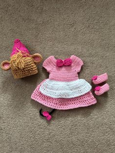 two crocheted items are laying on the floor next to each other, including a hat and booties