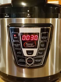 an electric pressure cooker with the time displayed on it's display, in a kitchen