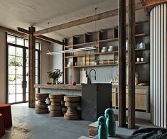 an open kitchen and dining area with wooden shelves, stools, and potted plants