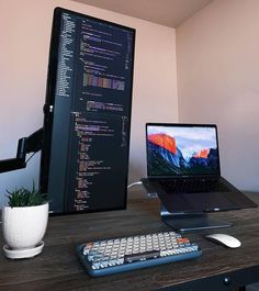 a laptop computer sitting on top of a wooden desk next to a keyboard and mouse