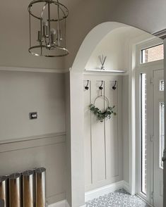 a hallway with white walls and an arched doorway