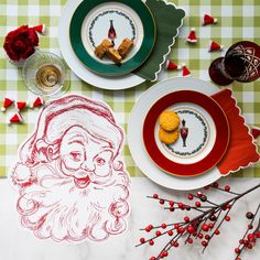 a table topped with plates and christmas decorations