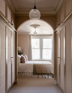 an arched doorway leads to a bedroom with a bed and two lamps on either side