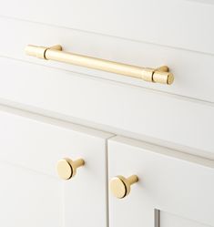 the handles and knobs on this white cabinet are brass - plated, but it's not too hard to tell