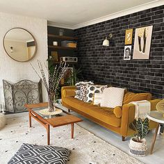 a living room with black brick walls and white carpeted flooring, yellow couches and coffee table