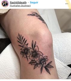 a black and white flower tattoo on the leg