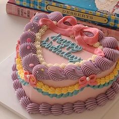 a birthday cake sitting on top of a table next to a book and some books