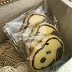 three decorated cookies in the shape of dogs are wrapped in cellophane and ready to be eaten