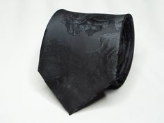 Transform any shirt into a stylish outfit with this modern necktie. A black on black floral tie perfect to pair with any suit.  Buy it for yourself or gift it. Makes a great gift for boyfriend, anniversary, birthday, groom, best man, father's day Christmas, or gift it just because. ABOUT * Black charcoal tie with a floral on floral pattern. * Dimensions: -Necktie: 8cm (3.15in) at the widest point. * These accessories are dry clean only. * Our shop has a huge selection of ties, pocket squares, cufflinks, and other suit accessories. * If you have any questions or concerns, please contact us and we will be able to assist you. PLEASE NOTE -> If you need your order on a certain date, please message before ordering to ensure your order arrives on time. Follow us on Instagram @the.gentlemens.era Semi-formal Black Suit And Tie Accessories, Black Standard Tie For Wedding Suits, Black Floral Tie, Boyfriend Anniversary, Wedding Tie, Slim Tie, Black On Black, Stylish Outfit, Pocket Squares