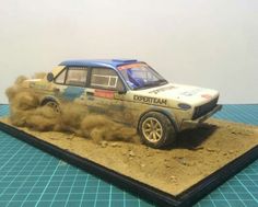 an old model car with dirt blowing up on it's roof and front wheels