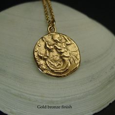 Handmade Greek coin reproduction of merman Triton, son of Poseidon necklace. Triton, son of Poseidon and Aphrodite, striking downward with a trident and holding fish. Triton is the messenger of the big sea. Like his father he carried a trident, but his special attribute was a twisted conch shell on which he blew to clam or raise the waves. - Handmade charm. - Solid yellow bronze also called jewelry gold bronze coin. - Nickel free - 14k gold filled chain - Gold filled has 100 times more gold than King Triton Crown, Trident Jewelry, King Triton Trident, Poseidon Necklace, Gold Mythological Jewelry With Coin Pendant, Big Sea, Greek Coins, Conch Shell, Handmade Charms