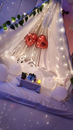 a bedroom decorated with balloons and lights for valentine's day or other special occasion