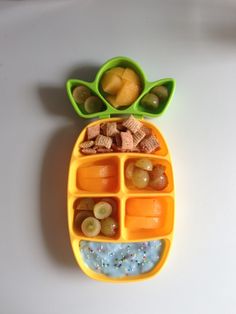 a pineapple shaped food tray with fruit and crackers in the shape of a pineapple