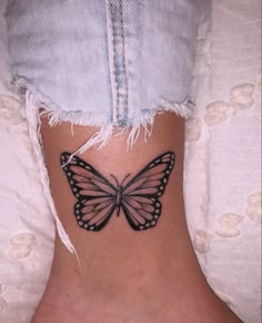 a small butterfly tattoo on the ankle