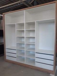 a large white bookcase with drawers and shelves in the middle of a garage area