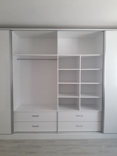 an empty white closet with drawers and shelves