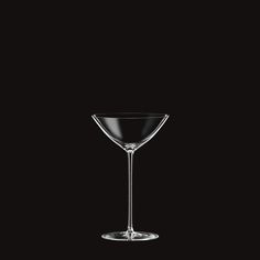 an empty martini glass on a black background