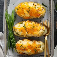 baked potatoes with cheese and chives on a tray