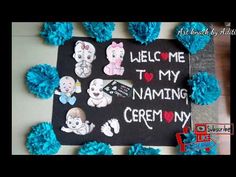 a chalkboard with some blue pom poms around it that says welcome to my naming ceremony