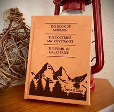 a book sitting on top of a wooden table next to a red lantern and some branches