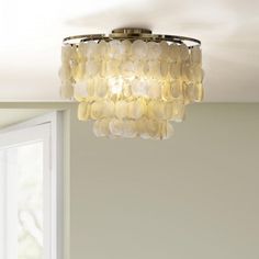 a chandelier hanging from the ceiling in a room with white walls and windows