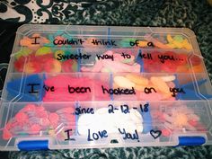 two plastic containers filled with different types of candies and writing on the lids that say i love you