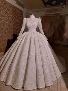 a white wedding dress on display in a room