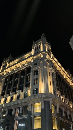 a large building lit up at night with lights on it's sides and windows