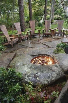 an outdoor fire pit with chairs around it