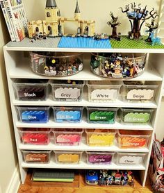 a shelf filled with lots of legos and other toy storage bins on top of it