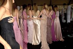 a group of women in long dresses standing next to each other at a fashion show