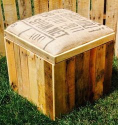 a wooden box sitting in the grass next to a wood fence with words written on it