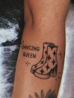 a tattoo with a boot and dancing queen written on it