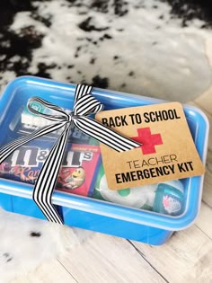 the back to school teacher emergency kit is packed in a blue container with a black and white ribbon