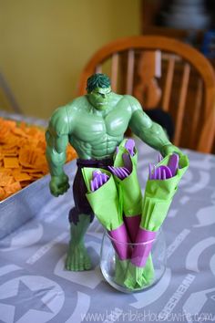 there is a hulk action figure sitting in a vase on the table with some flowers