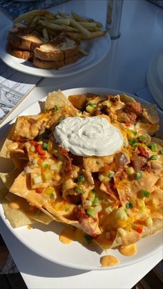 nachos with sour cream and vegetables on a white plate