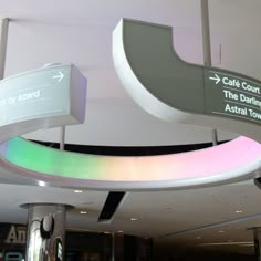 an airport lobby with signs on the ceiling