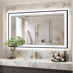 a bathroom with marble counter tops and a large mirror above the sink that's illuminated