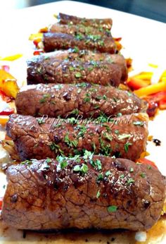 some very tasty looking food on a cutting board with peppers and seasoning sprinkles