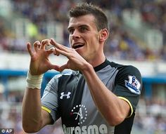 a soccer player holding his hands in the air and making a heart shape with his fingers